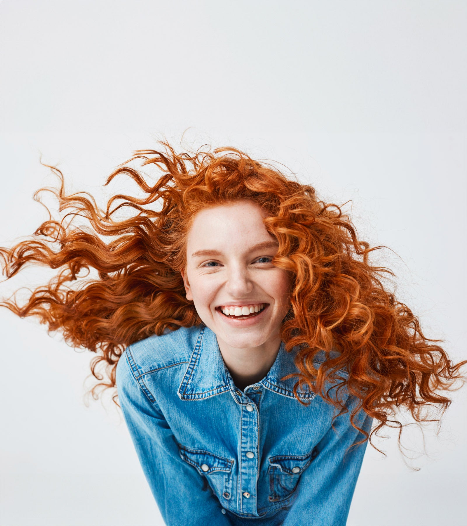 A woman with curly hair smiling to the camera