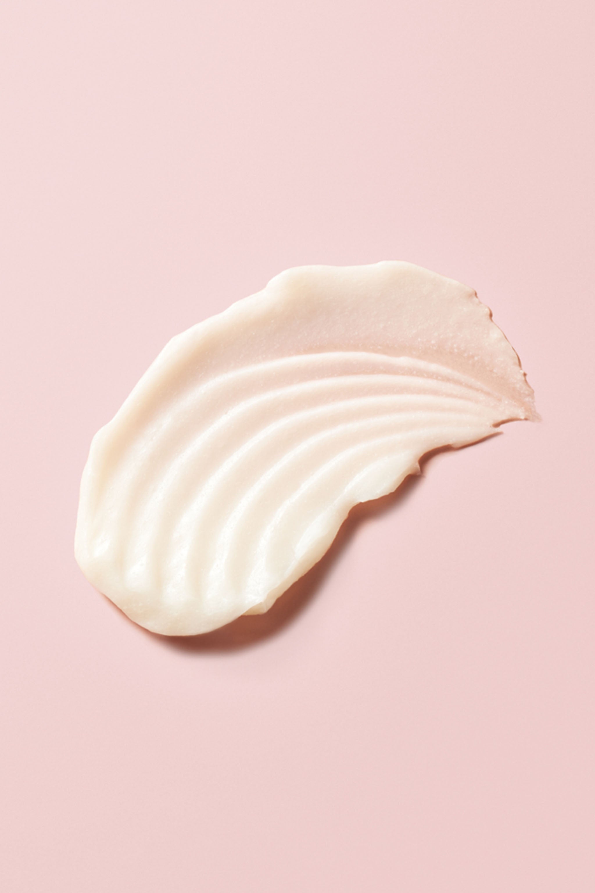 Portion of Advanced Climate Control® Frizz-Fighting Hydrating Mask on pink background