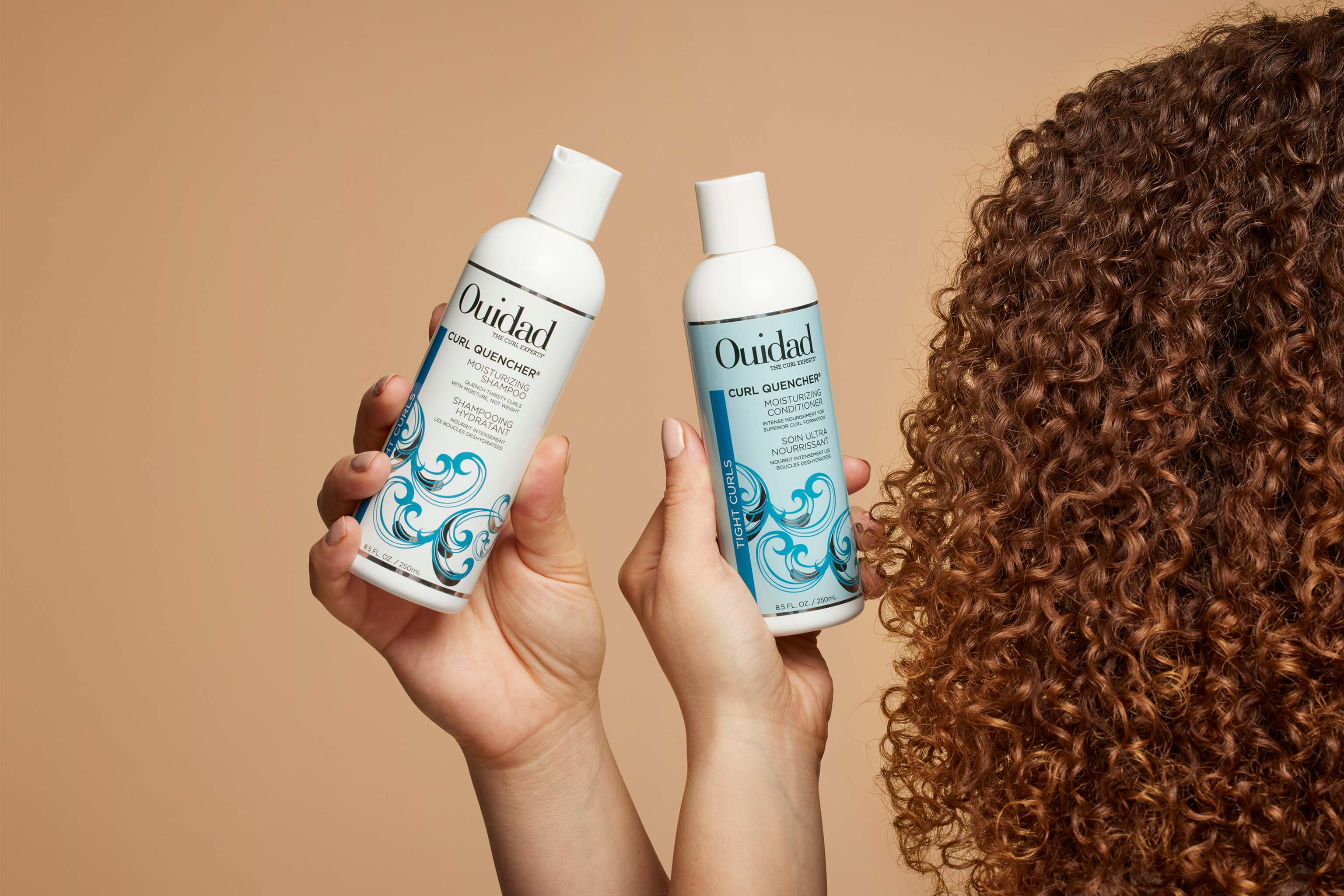 Model holding Curl Quencher® Shampoo and Conditioner