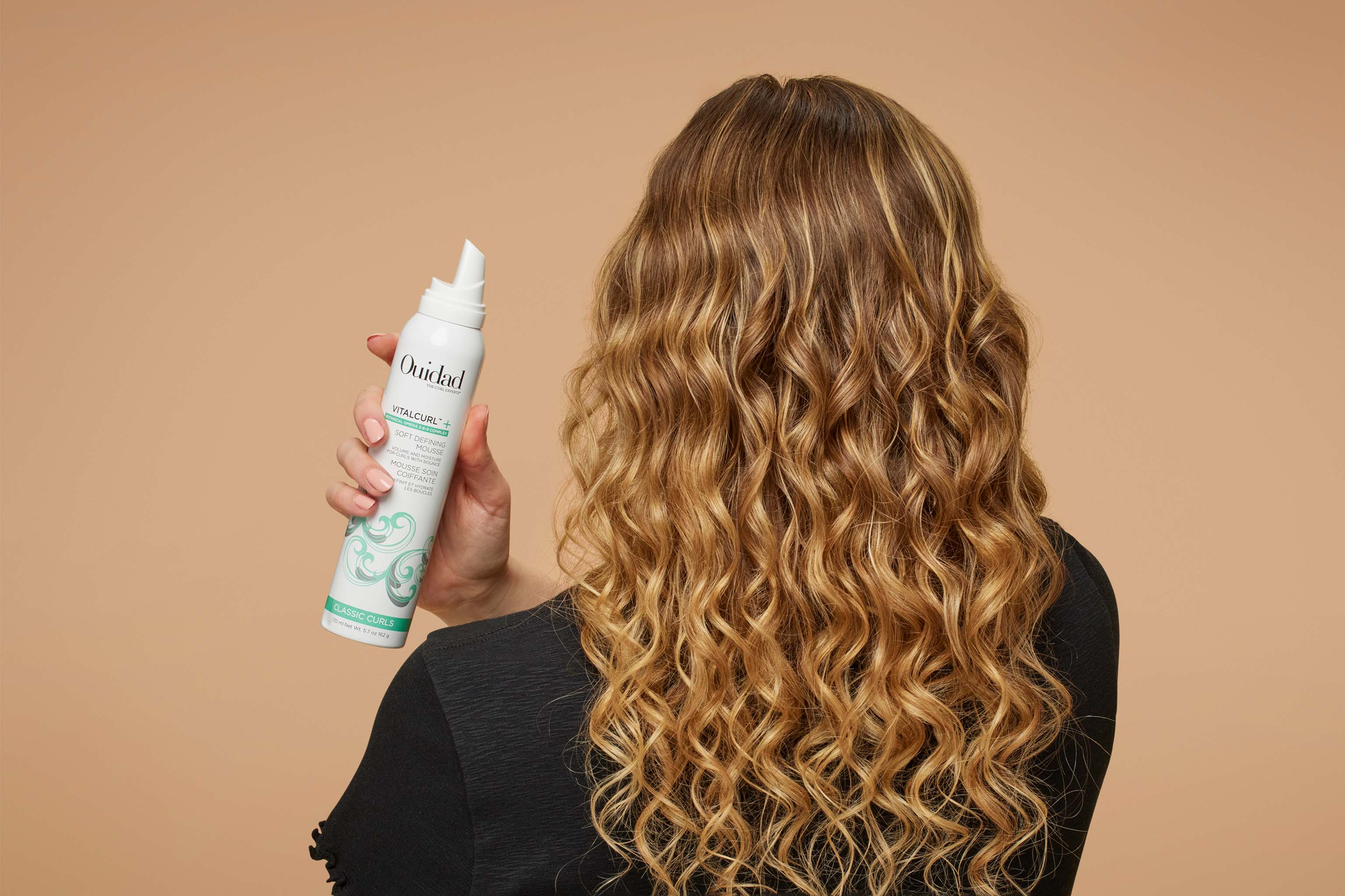 Model holding VitalCurl®+ Soft Defining Mousse