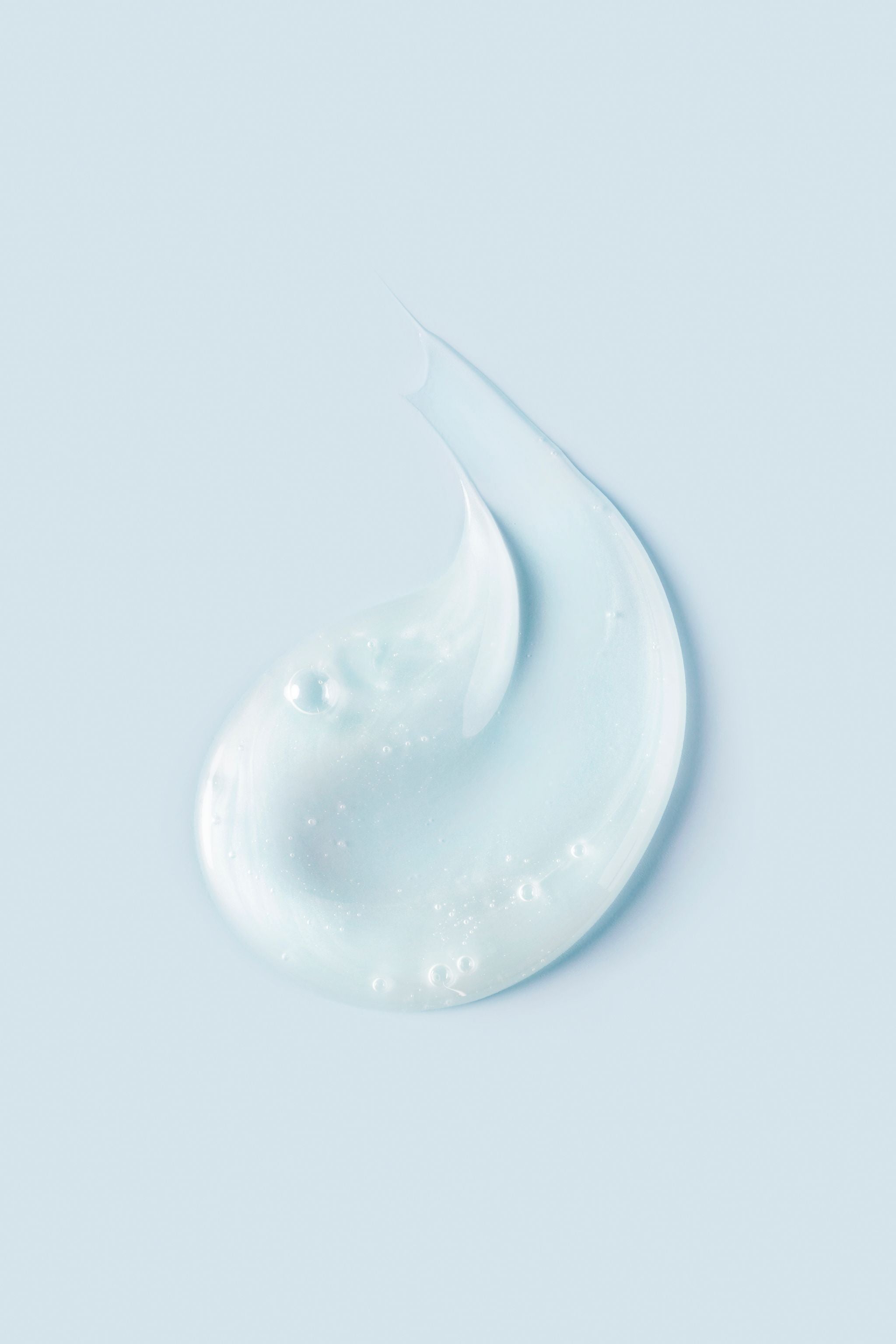 Portion of light blue Curl Quencher® Moisturizing Shampoo on light blue background