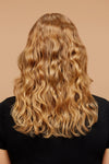 Model showing off wavy blonde hair facing away from the camera.